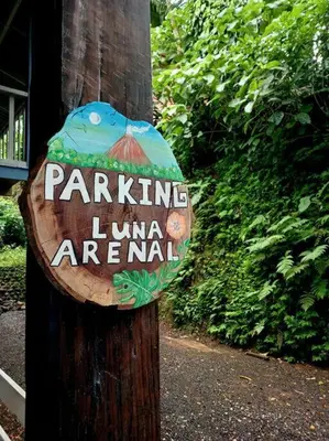 a sign on a wooden pole with a sign on it at Cabaña Luna Arenal in Fortuna