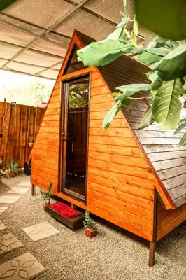 a small wooden house with a window and plants at Rousse Cabin in Rivas