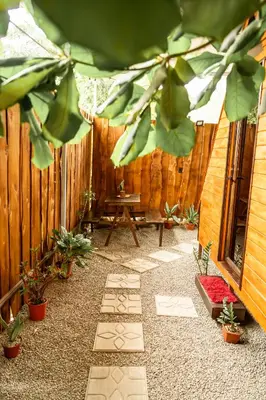 a patio with a wooden fence and a table and plants at Rousse Cabin in Rivas