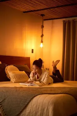 a woman laying on a bed reading a book at Villa Natura in Bajos del Toro
