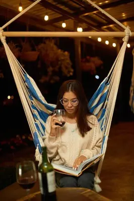 a woman sitting in a hammock with a glass of wine at Villa Natura in Bajos del Toro