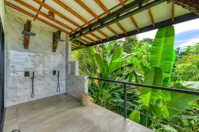 a master bathroom with a shower and large green plants at Bali Villa Jungle Paradise - Uvita in Uvita