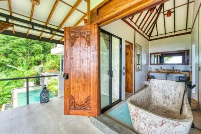 a room with a large wooden door and a balcony at Bali Villa Jungle Paradise - Uvita in Uvita