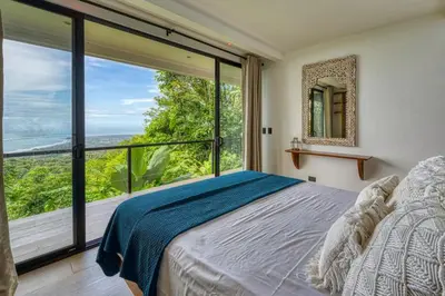 a bedroom with a bed and a large window at Bali Villa Jungle Paradise - Uvita in Uvita
