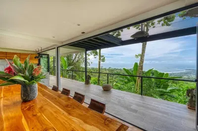 a dining room with a table and a large window at Bali Villa Jungle Paradise - Uvita in Uvita