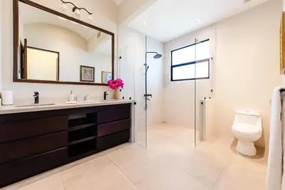 a bathroom with a sink and a toilet and a mirror at Golf from home! 8BR Lux Villa, Pool, Beach Club! in Playa Avellana