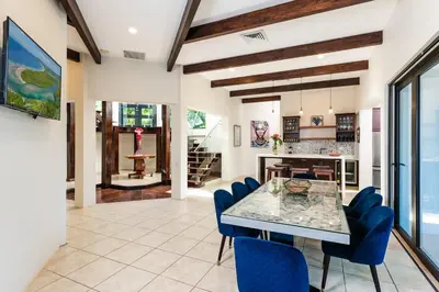 a dining room with a glass table and blue chairs at Golf from home! 8BR Lux Villa, Pool, Beach Club! in Playa Avellana
