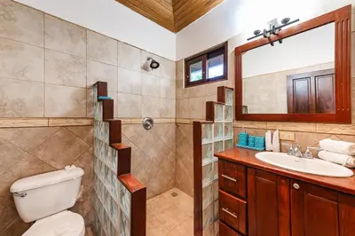 a bathroom with a toilet and a sink and a mirror at Golf from home! 8BR Lux Villa, Pool, Beach Club! in Playa Avellana