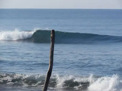 a stick sticking out of the ocean with waves at #17A Hermosa Beach Bungalow 1st floor 1 bedroom Apt in Playa Hermosa