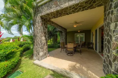 a patio with a table and chairs on a house at Vista Bahia 1G 3 bdr Ocean View in Los Suenos in Herradura