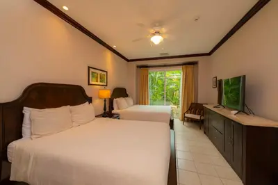 a bedroom with two beds and a flat screen tv at Vista Bahia 1G 3 bdr Ocean View in Los Suenos in Herradura