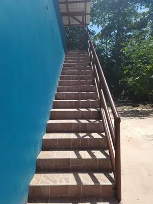 a stairway leading up to a blue building at Alma Del Bosque Hotel in Tortuguero