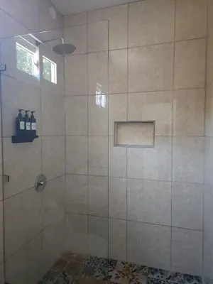 a shower with a glass door in a bathroom at Alma Del Bosque Hotel in Tortuguero