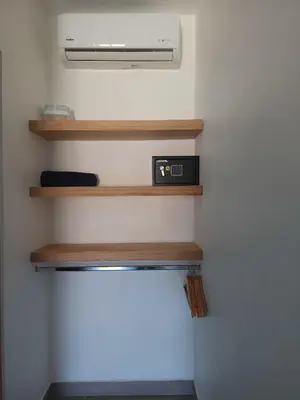 a room with wooden shelves and a air conditioner at Alma Del Bosque Hotel in Tortuguero