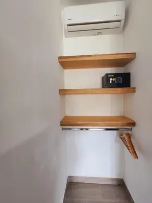 a room with wooden shelves and a air conditioner at Alma Del Bosque Hotel in Tortuguero