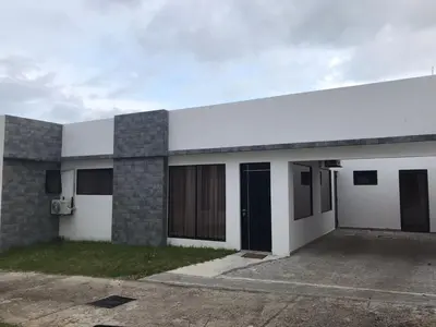 a white and gray building with a parking lot at Casa Yani Santa teresa in San Isidro