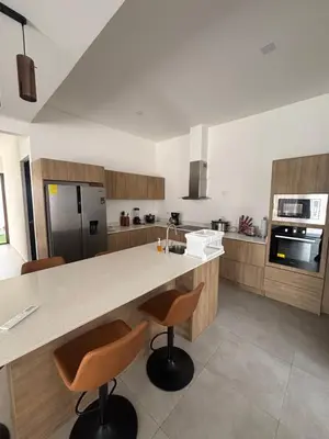 a kitchen with a large counter with two stools at Casa Yani Santa teresa in San Isidro