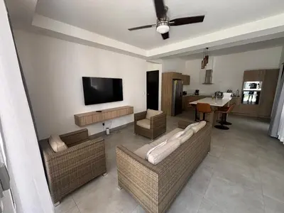 a living room with couches and a flat screen tv at Casa Yani Santa teresa in San Isidro