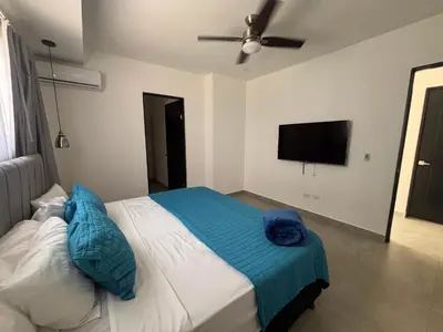 a bedroom with a bed and a flat screen tv at Casa Yani Santa teresa in San Isidro