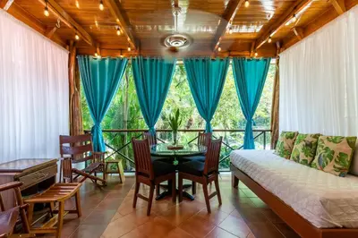 a living room with a bed and a table and chairs at Namaste Beach Bungalow 1 BDR Loft 4 Min to Beach in Nosara