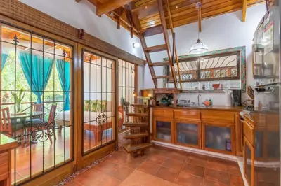 a kitchen with a spiral staircase in a house at Namaste Beach Bungalow 1 BDR Loft 4 Min to Beach in Nosara