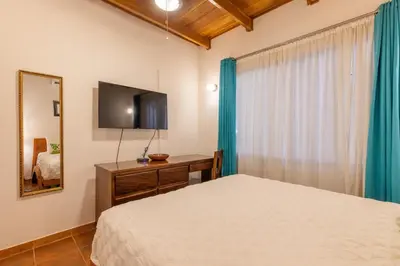 a bedroom with a bed and a flat screen tv at Namaste Beach Bungalow 1 BDR Loft 4 Min to Beach in Nosara
