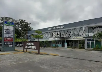 a parking lot in front of a large building at Cabinas La Sirena in Puntarenas