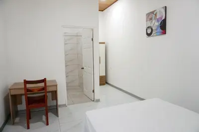 a bedroom with a table and a chair and a door at Cabinas La Sirena in Puntarenas