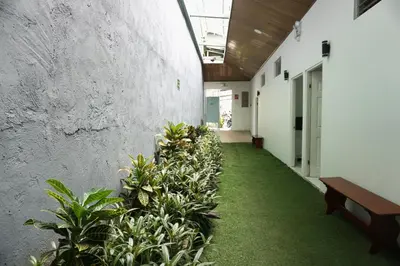 a hallway with plants and benches in a building at Cabinas La Sirena in Puntarenas
