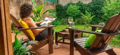 a woman sitting in a chair on a patio at Turrialba Bed & Breakfast in Turrialba