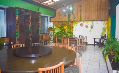 a restaurant with a large wooden table and chairs at Turrialba Bed & Breakfast in Turrialba