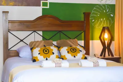 a bedroom with a bed with pillows on it at Turrialba Bed & Breakfast in Turrialba