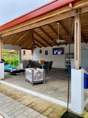 a patio with awning and a tv in a house at Hermosa casa en Esterillos in Esterillos Este