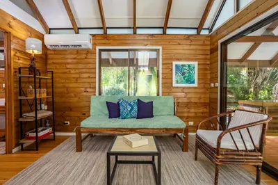 a living room with a couch and a chair at Casa Serena - Tranquil Jungle Gem Near the Beach in Uvita