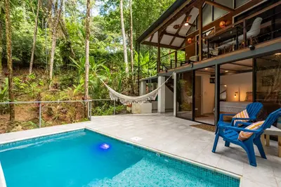 a pool in front of a house with a hammock at Casa Serena - Tranquil Jungle Gem Near the Beach in Uvita