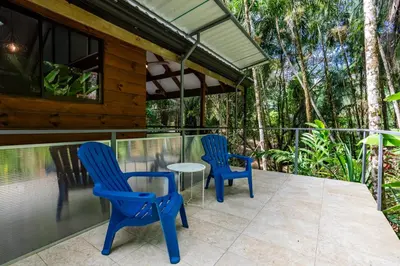 two blue chairs and a table on a patio at Casa Serena - Tranquil Jungle Gem Near the Beach in Uvita
