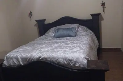 a bed with a wooden head board with a blue pillow at Aurora Retreat Costa Rica in Tilarán