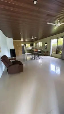 a large living room with a couch and tables at Casita Verde in Uvita