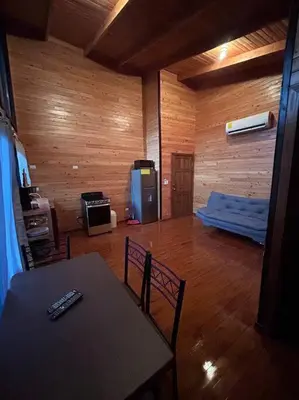 a living room with a table and chairs and a television at Seahorse Breeze Apartment 1 in Uvita