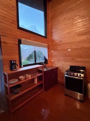 a kitchen with a stove and a window in a cabin at Seahorse Breeze Apartment 1 in Uvita