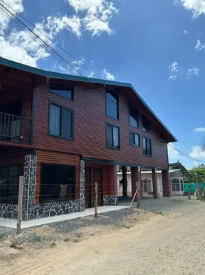 a large wooden house on a dirt road at Seahorse Breeze Apartment 1 in Uvita
