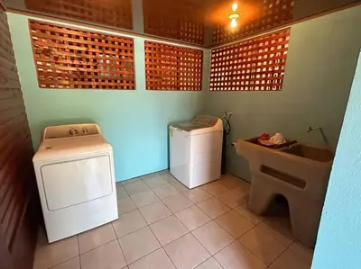 a bathroom with a washing machine and a sink at Seahorse Breeze Apartment 2 in Uvita