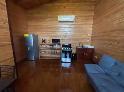 a kitchen with a stove and a couch in a room at Seahorse Breeze Apartment 2 in Uvita