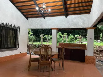 a dining room with a table and chairs on a patio at Villa Lagunillas in Lagunillas