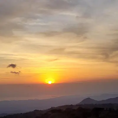 a sunset over the mountains with the sun in the sky at Tierra Vital Atenas Villa 2 in Atenas