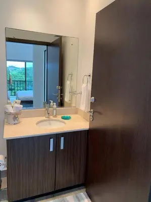 a bathroom with a sink and a large mirror at Spacious and Modern Penthouse Condo in Jacó