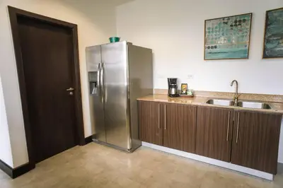 a kitchen with a stainless steel refrigerator and a sink at Spacious and Modern Penthouse Condo in Jacó