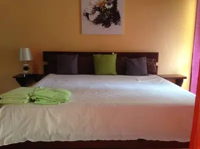 a bedroom with a white bed with green towels on it at BEACH OPEN-FLAT with TERRACE ANALIA in Manuel Antonio