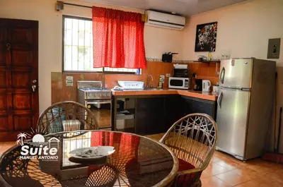 a kitchen with a stainless steel refrigerator and a table at BEACH OPEN-FLAT with TERRACE ANALIA in Manuel Antonio