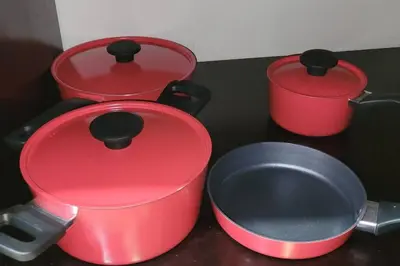 three red pots and pans sitting on a counter at Local secret apartament Blue Mountain in Quepos in Quepos